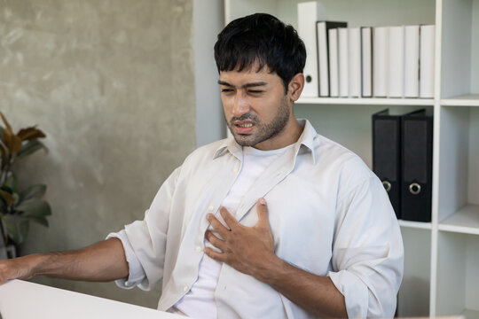 Acid reflux disease, business man has symptoms of heartburn, esophageal, stomach ache, hand on chest from digestion problem after eating food at irregular times, dyspepsia, spicy food
