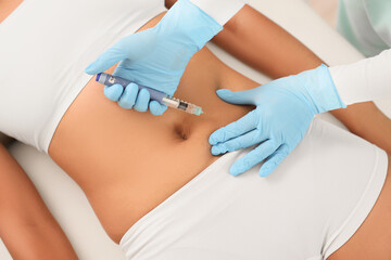 Doctor injecting woman on couch, top view. Weight loss concept