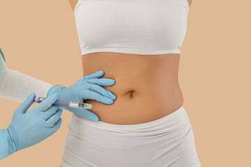 Doctor injecting woman on beige background, closeup. Weight loss concept