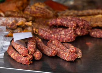 Variety of cured sausages on display at market stall