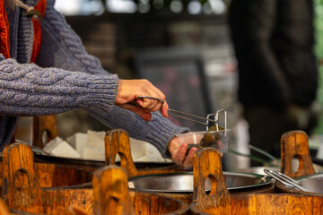 Asian street food vendor serving tofu at outdoor market
