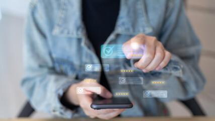 A person using a smartphone and touching virtual five-star rating icons, representing customer feedback, online review system, and user experience evaluation concept.