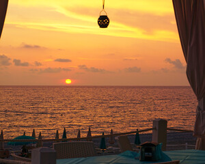 Serene beach sunset from a cozy seaside cafe.