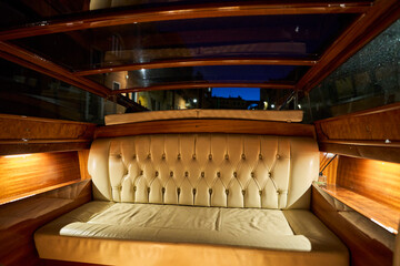 Luxurious leather seating inside a wooden boat.