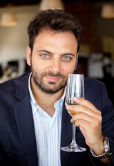 Man holding sparkling wine glass celebrating and tasting