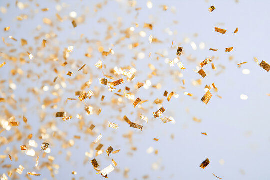 golden confetti on a light blue background.