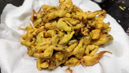 Closeup of freshly prepared Indian snacks pakoda or fritters served on a plate with selective focus. Perfect for illustrating Indian cuisine, street food, homemade recipes, and traditional snacks.
