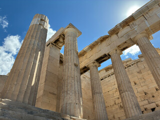 Close up detail of Parthenon columns in Athens creating artistic ancient architectural lines and textures under bright sunlight and blue sky.