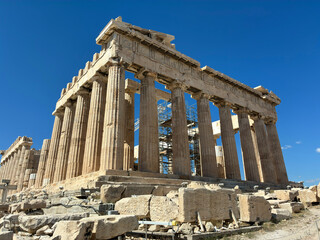 Obraz premium Full view of the Parthenon temple at the Acropolis of Athens on a bright sunny day with blue skies, ancient marble textures and Greek heritage architecture.