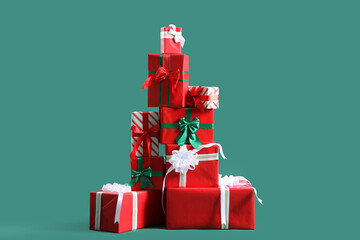 Stack of Christmas gifts on green background