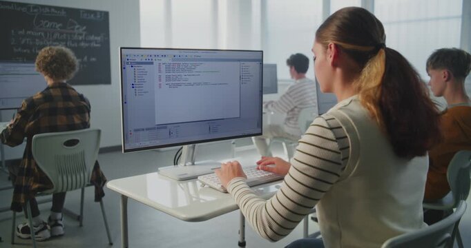 Female Student Performs Practical Coding Task. At University, During Game Dev Lecture, Young Woman Writes Program Code. Concept Modern Education, Studying Computer Science, Future Technology Skills.