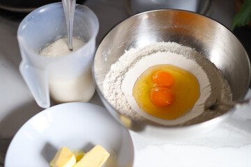 Baking ingredients: eggs, flour, butter, and sugar in preparation for mixing