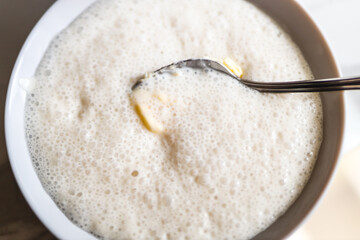 Creamy homemade tapioca pudding with spoon in white bowl