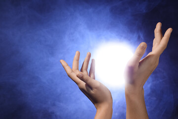 Female hands with ball of energy on black background