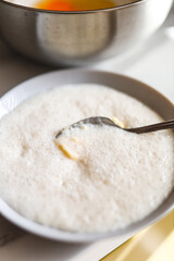 Creamy bowl of hot porridge with spoon in kitchen setting