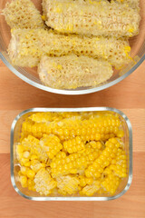 Corn Cob and Kernels SeparationAn overhead shot features two clear glass containers on a wooden table, one holding yellow corn kernels, and the other containing the scraped-off white cobs