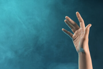 Female hand with blue energy on black background