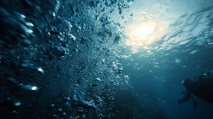 A diver explores the underwater world, surrounded by bubbles rising. As the diver swims, sunlight penetrates the water, creating bubbles around the diver's silhouette.