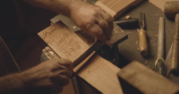 Man working with wood, making a tradional portuguese guitar, traditional carpentry, 4K slow motion