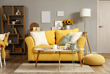 Interior of stylish living room with yellow sofa and artificial houseplant on coffee table