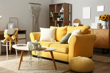 Interior of stylish living room with yellow sofa and artificial houseplant on coffee table