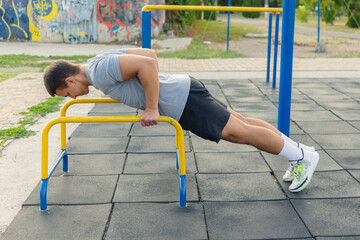 	
Young man training on outdoor sports ground	
