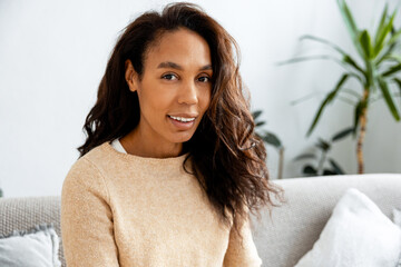 Woman smiling at home relaxing on sofa