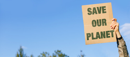 Activist Male hand up, holds a Save the Planet on nature and blue sky background. Environmental concerns. Ecology Protest.