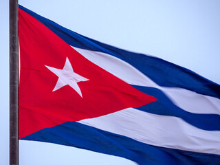 Cuba Flag Waving on flagpole, close up. Cuba flag flaping in wind. Close-up of an Cuban flag flying in the wind against a background of clear sky. Cuba flag full frame