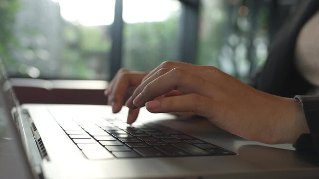 Close up of woman s hands typing on modern laptop in a bright workspace. Digital business, remote work, and tech lifestyle.