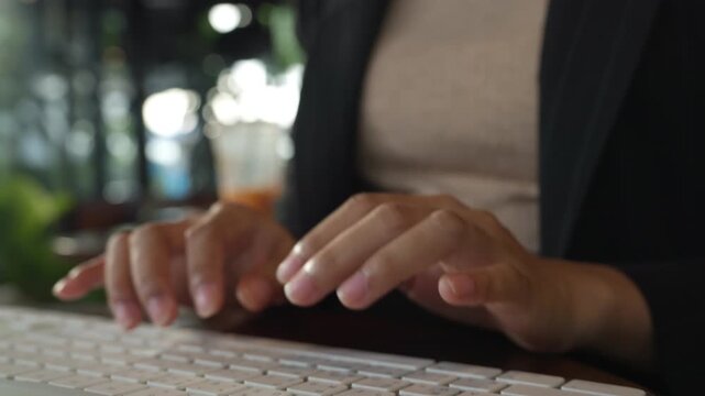 Macro shot of female fingers typing on sleek laptop. Suitable for themes of technology, IT work, and data entry.