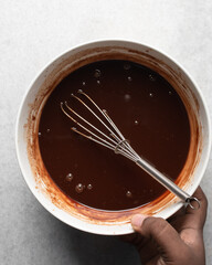 Overhead view of dark chocolate mud cake batter in a mixing bowl, process of making chocolate mud cake