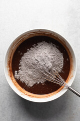 Overhead view of dark chocolate mud cake batter in a mixing bowl, process of making chocolate mud cake