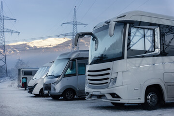 Scenic many different modern campervan motor home van parked camper park site lot Austria at sunrise sunset Kaprun mountain landscape. Motorhome campground station travel destination. RV lifestyle