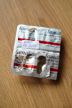 Expired Lamaline pain medication blister pack from February 2016 lying on a wooden table, representing outdated pharmaceuticals