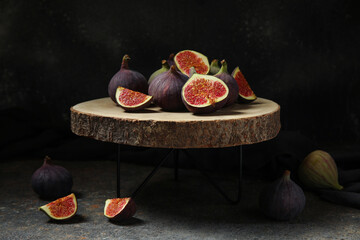 Wooden stand with fresh ripe figs on grunge table