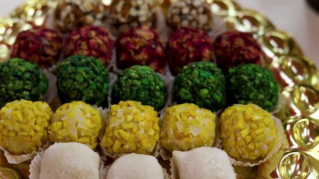 Colorful dry fruit laddu or balls in a gold plate with festival background