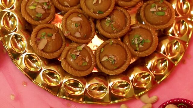 Chandrakala beautifully decorated in a golden plate with festive celebration background