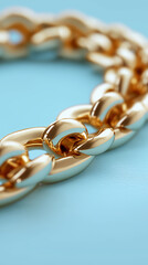 Obraz premium Close-up of a shiny gold chain bracelet on a light blue background. 