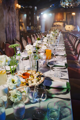 Long dining table set for a celebration with elegant decor and food offerings