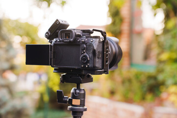 Camera on tripod ready for outdoor photography in a garden setting
