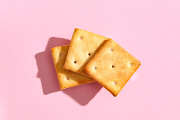 Composition with tasty crackers on pink background, closeup