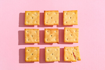 Composition with tasty crackers on pink background, closeup