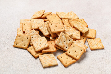Heap of tasty crackers on beige grunge background, closeup