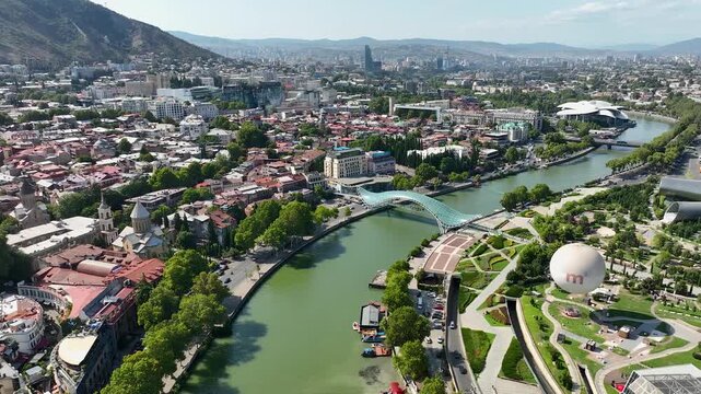 Tbilisi, Georgia. Scenic aerial view Of Famous Landmarks. Cityscape. Overview of the Kura (Mtkvari) River in Old Town, Tbilisi city central park and Bridge of Peace