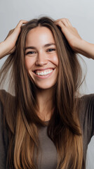 Fototapeta premium Smiling young woman with long hair looking at camera in natural light. 