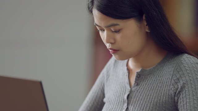 A student participating in an online class, typing lecture notes on a laptop.