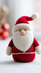 Cute handmade Santa Claus figurine in red suit and white beard standing on a light background.
