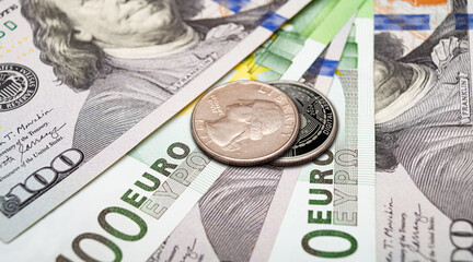 Crypto coins placed on top of bank notes show the relationship between traditional and digital currencies