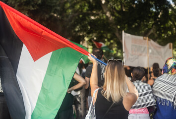 Young caucasian woman protest at free Palestine demonstration - Solidarity and march against genocide concept - Focus on flag
